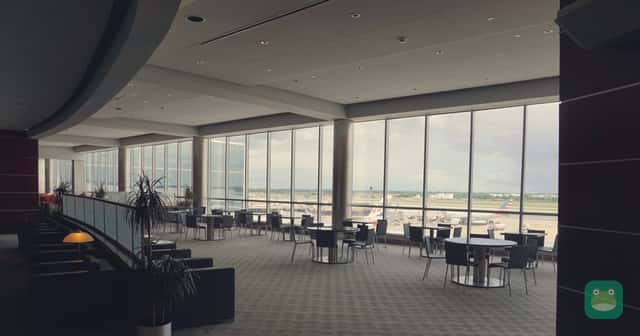Tables and chairs by the windows of an airport lounge at Philadelphia International Airport.