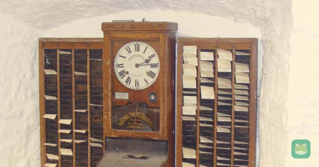 An antique time clock between two racks of punch cards, in the museum at Wookey Hole Caves in England.