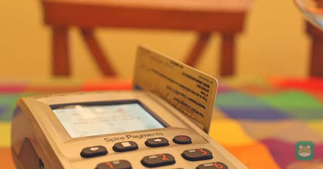 A payment card inserted in a card payment terminal on a table.